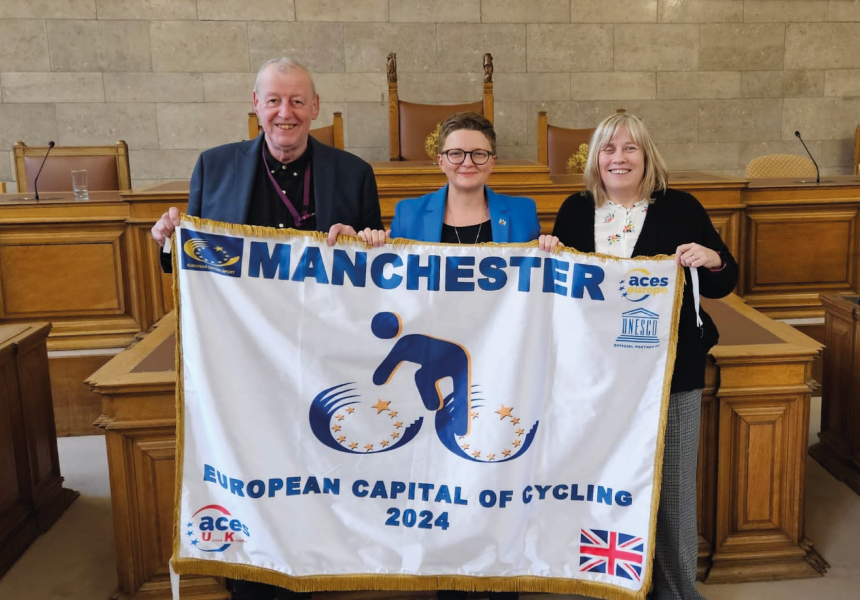 Group of people holding up a flag saying European Capital of Cycling 2024