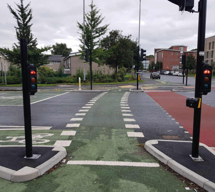 A multi-use traffic junction with protected cycle lanes and pedestrain crossings alongside vehicles
