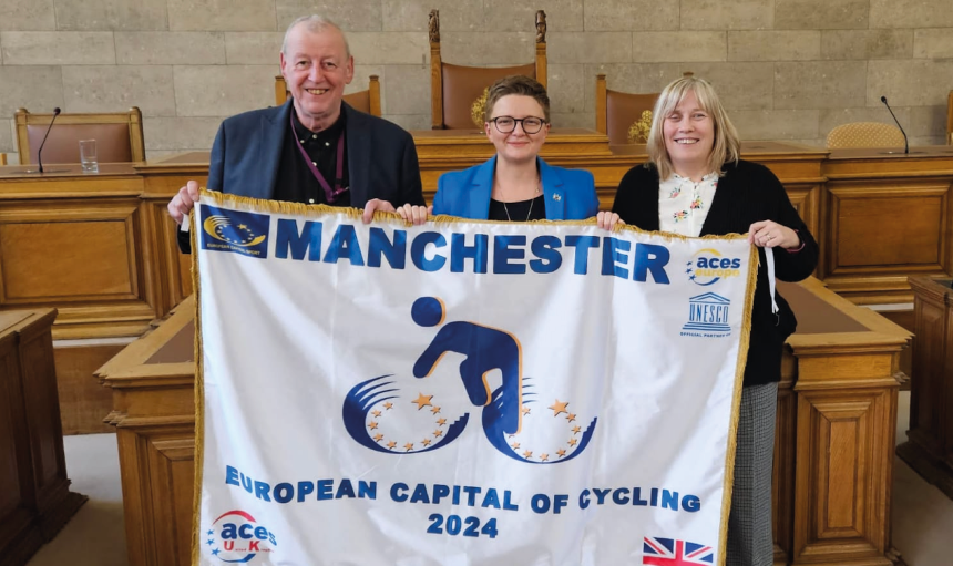 Group of people holding up a flag saying European Capital of Cycling 2024