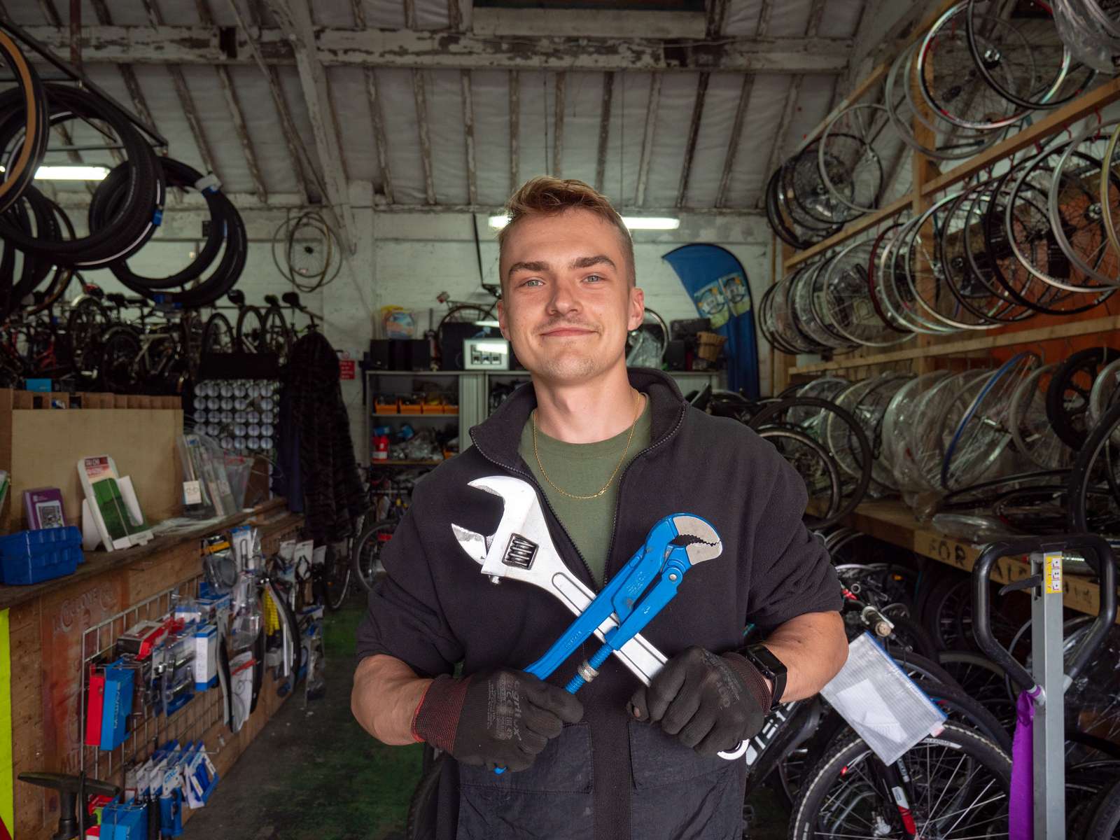 A person holding tools in a bike workshop