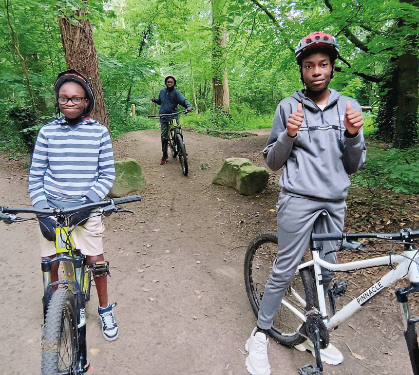 Kids on bikes in park with lots of trees