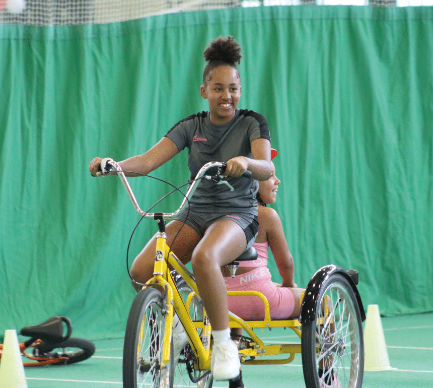 Children smiling on trike at family sports taster day event