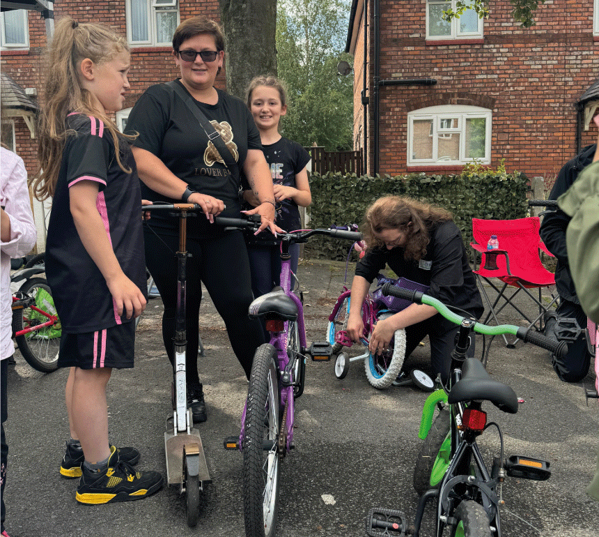 Girls fixing bikes at West Fest in Burnage