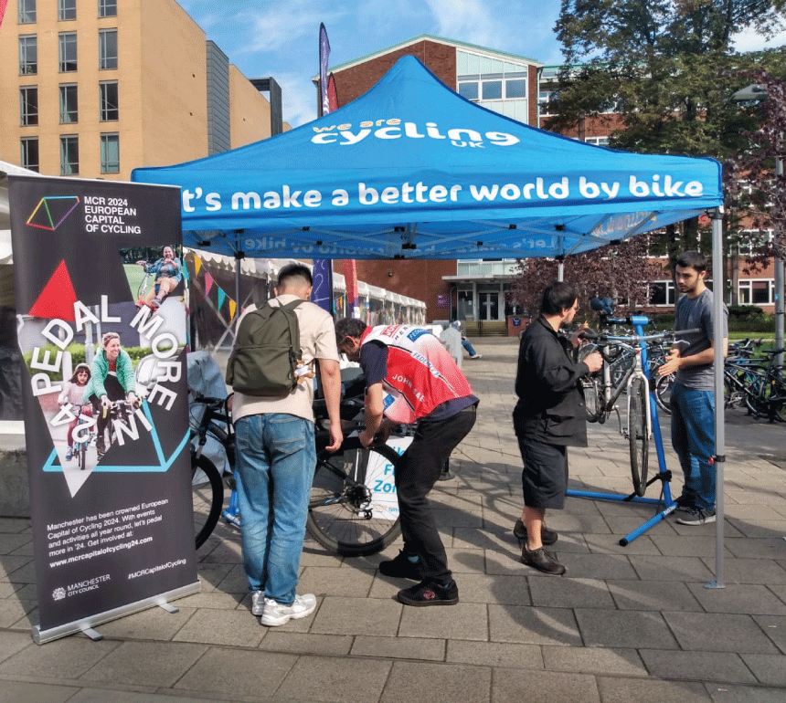 People receiving bike maintenance at pop up event on Oxford Road Manchester