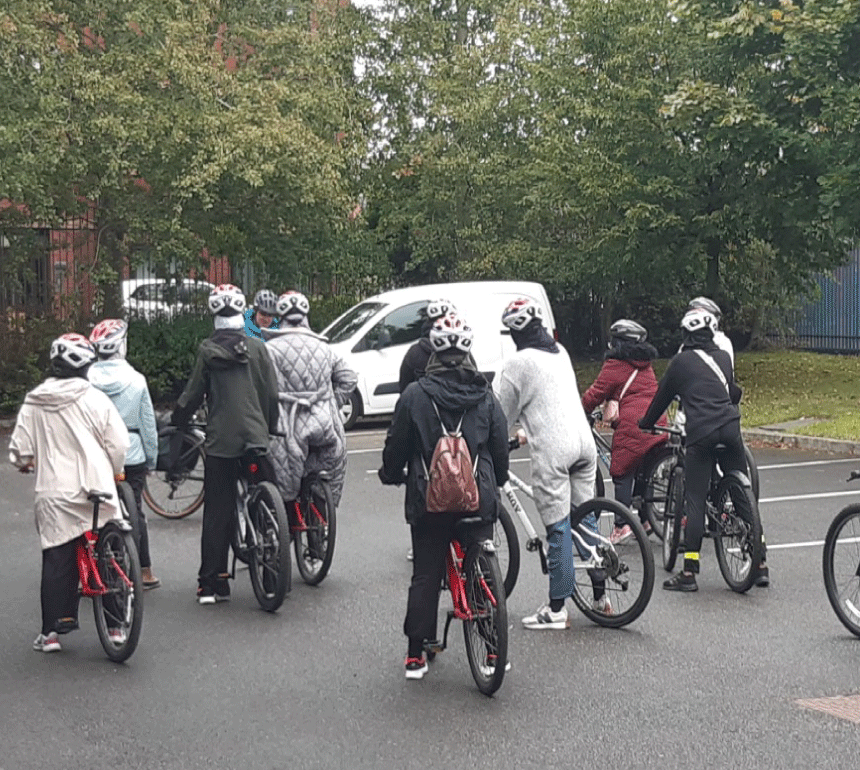 Group of Women receiving bike riding lessons outdoors