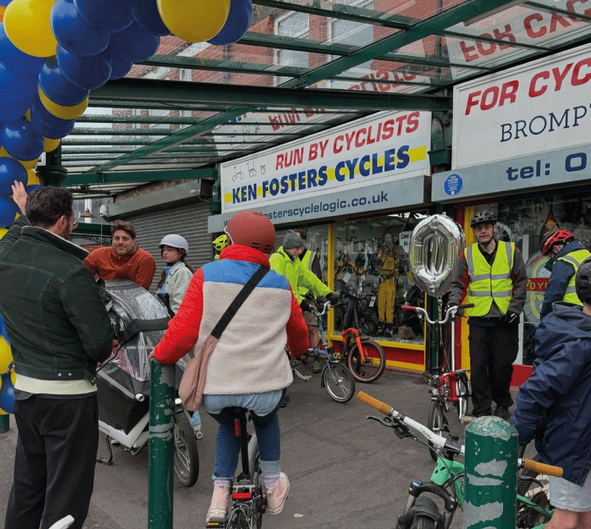 People on bikes outside Ken Fosters Cycles for the shop's 70th anniversary